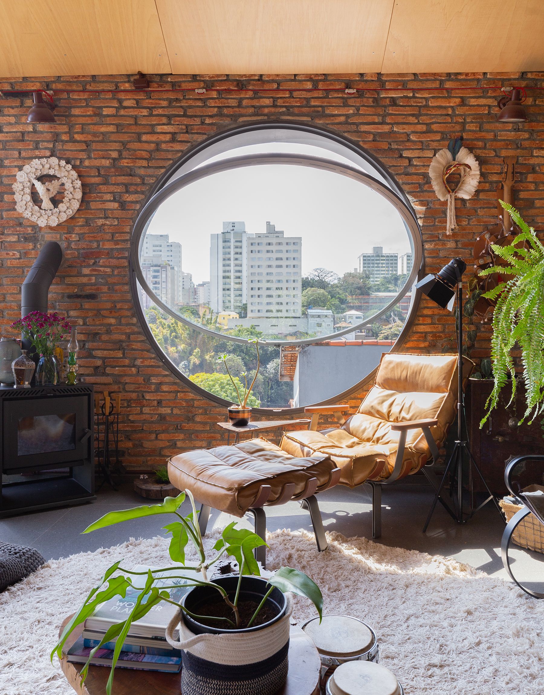 Arquitetura com estilo industrial, casa com tijolinhos e plantas, janelas redondas