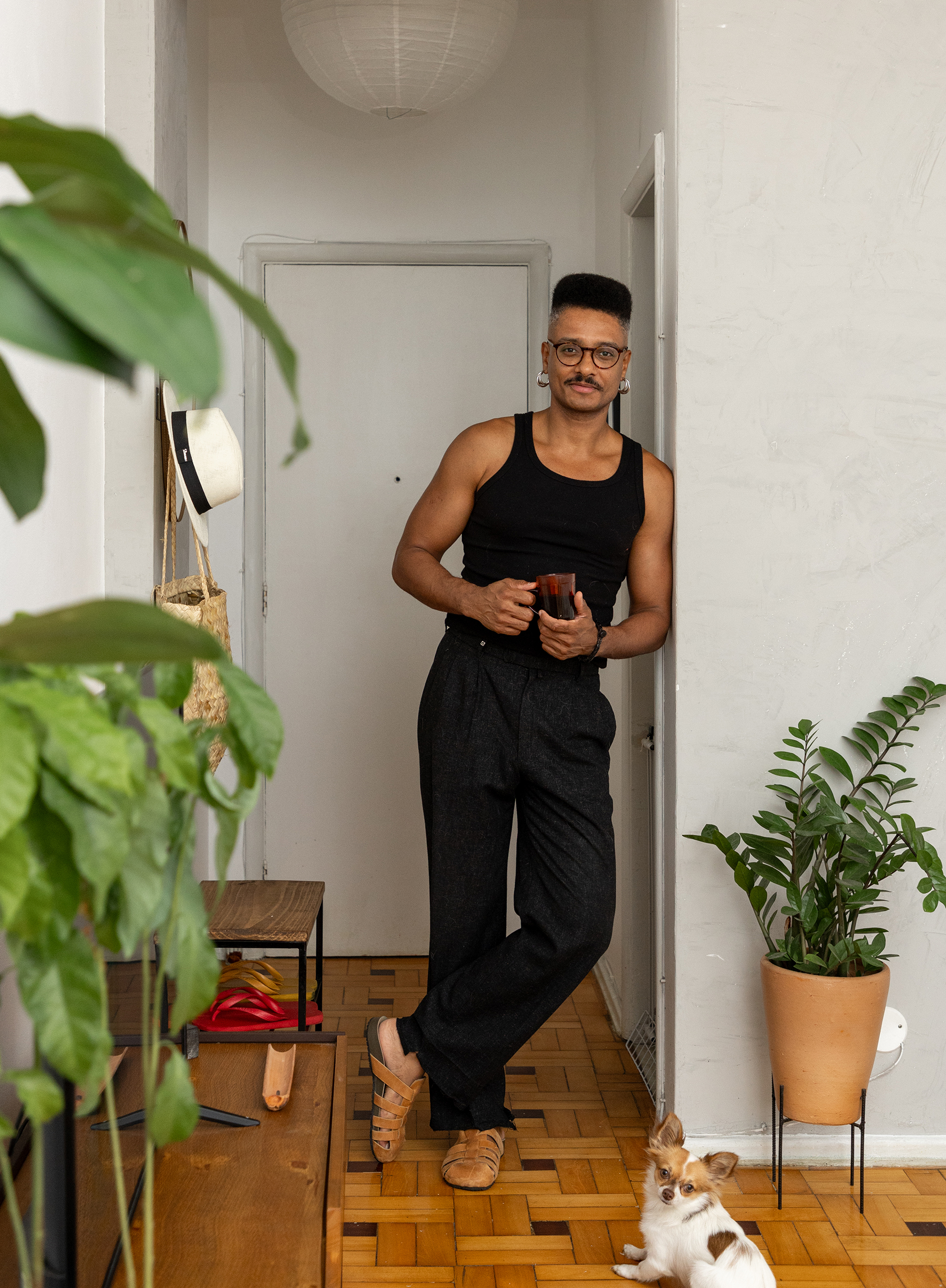 Apartamento com vista para a praia no Rio de Janeiro tem piso de tacos e decoração com plantas.