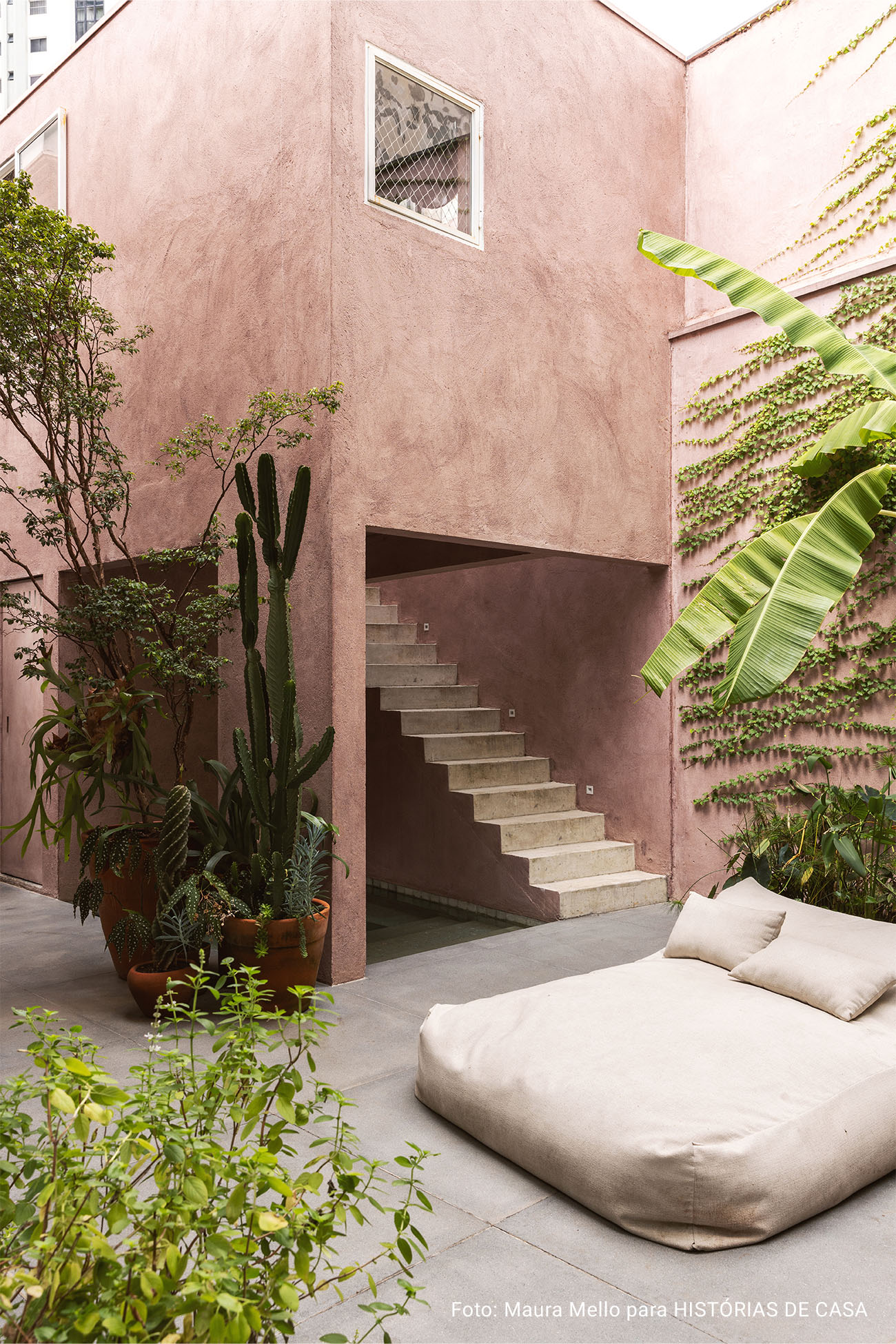 Casa com espaços integrados, muitas obras de arte e área externa cor-de-rosa.
