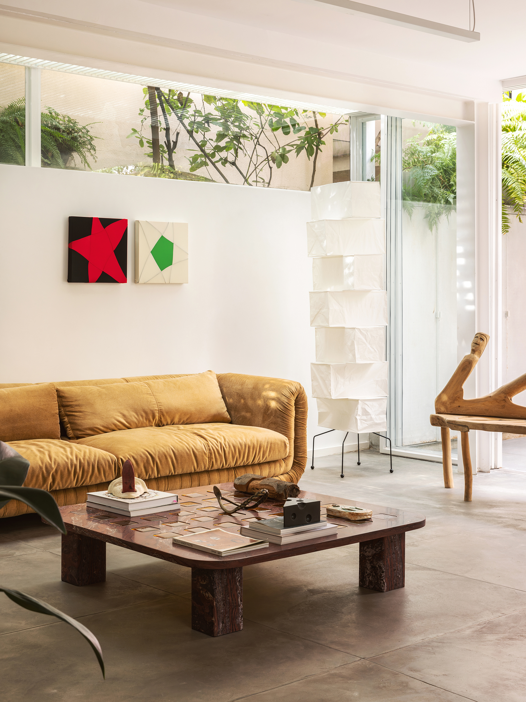 Casa com espaços integrados, muitas obras de arte e área externa cor-de-rosa.