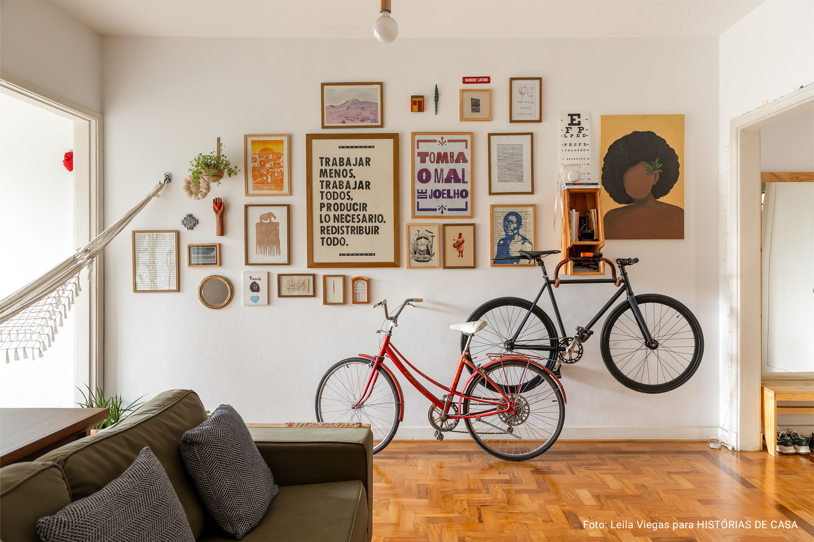 Apartamento com piso de taco, cômodos integrados, sala de jantar pintada de azul e quarto com parede marrom.