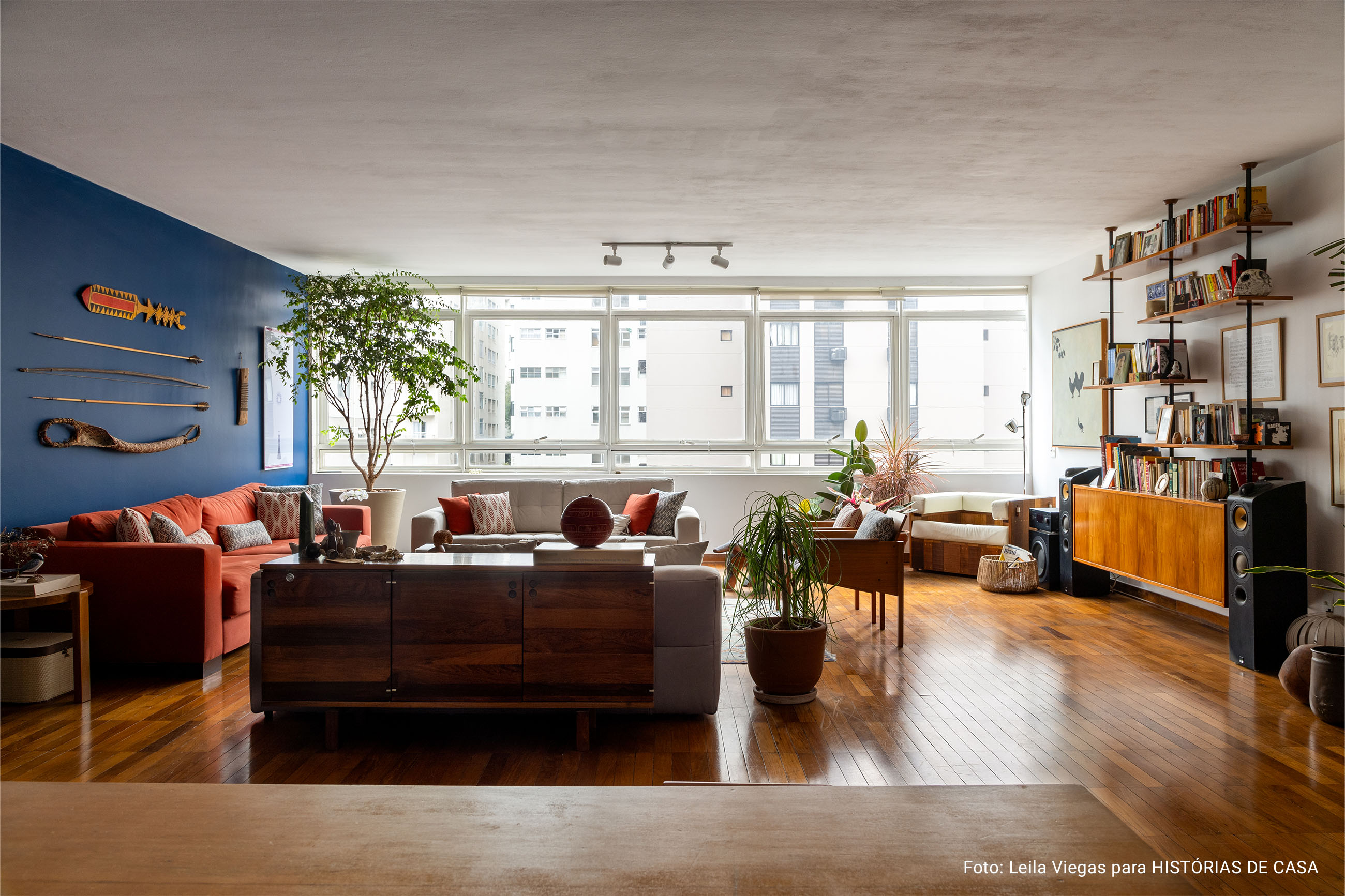 Decoração com parede azul, janela ampla e influências afro-indígenas.