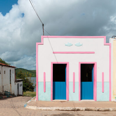 Casa Pirambeba na Ilha do Ferro com fachada colorida e decoração com peças de artesanato popular.