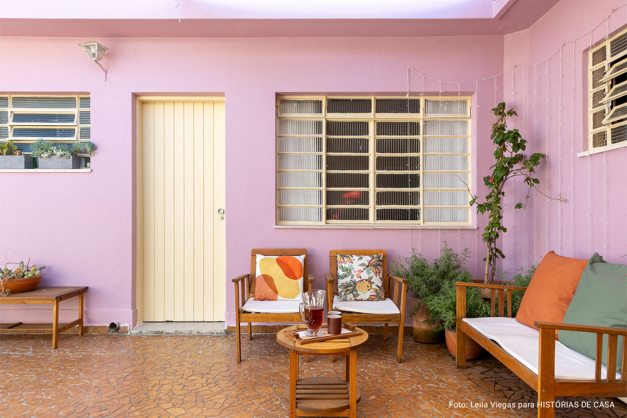 Casa de vó com decoração acolhedora e quintal com rede e plantas e piso de caquinho.