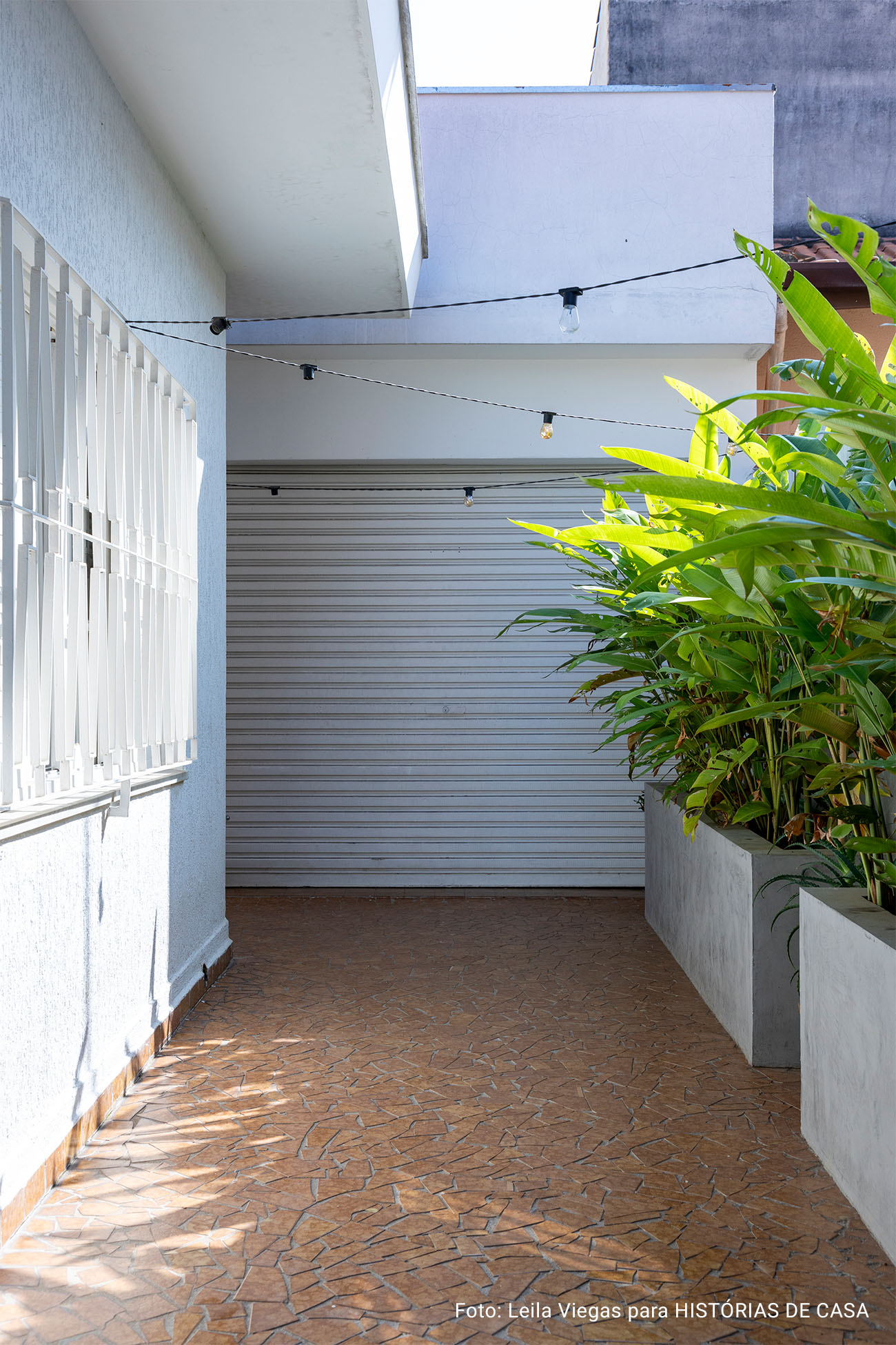 Casa de vó com decoração acolhedora e quintal com rede e plantas e piso de caquinho.