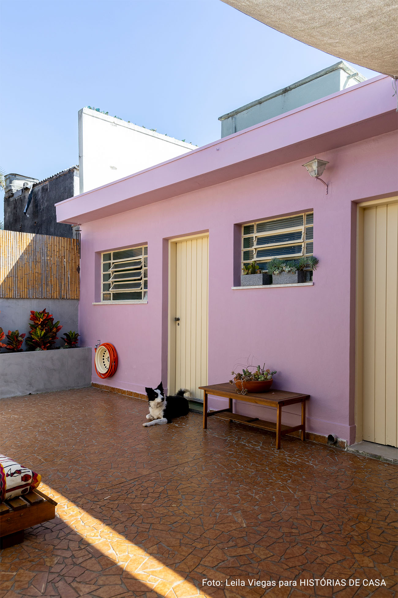 Casa de vó com decoração acolhedora e quintal com rede e plantas e piso de caquinho.