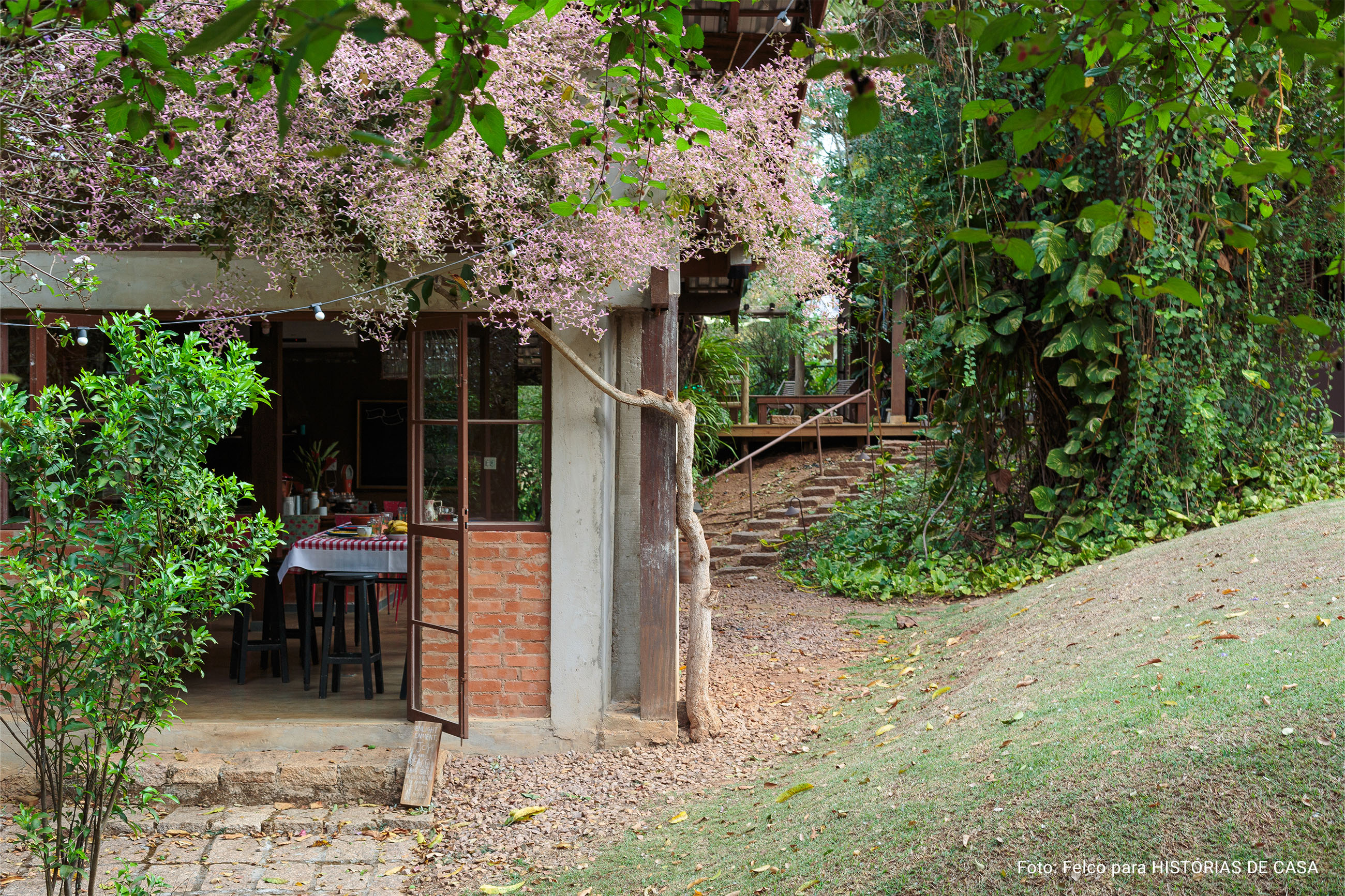 Casa de campo com cozinha aberta para a natureza e mesa posta com louças da Tok&Stok