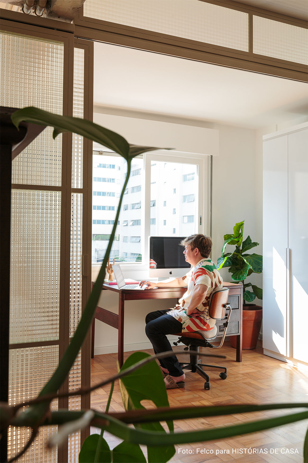 Apartamento minimalista com cozinha integrada, piso de caquinhos e porta de serralheria