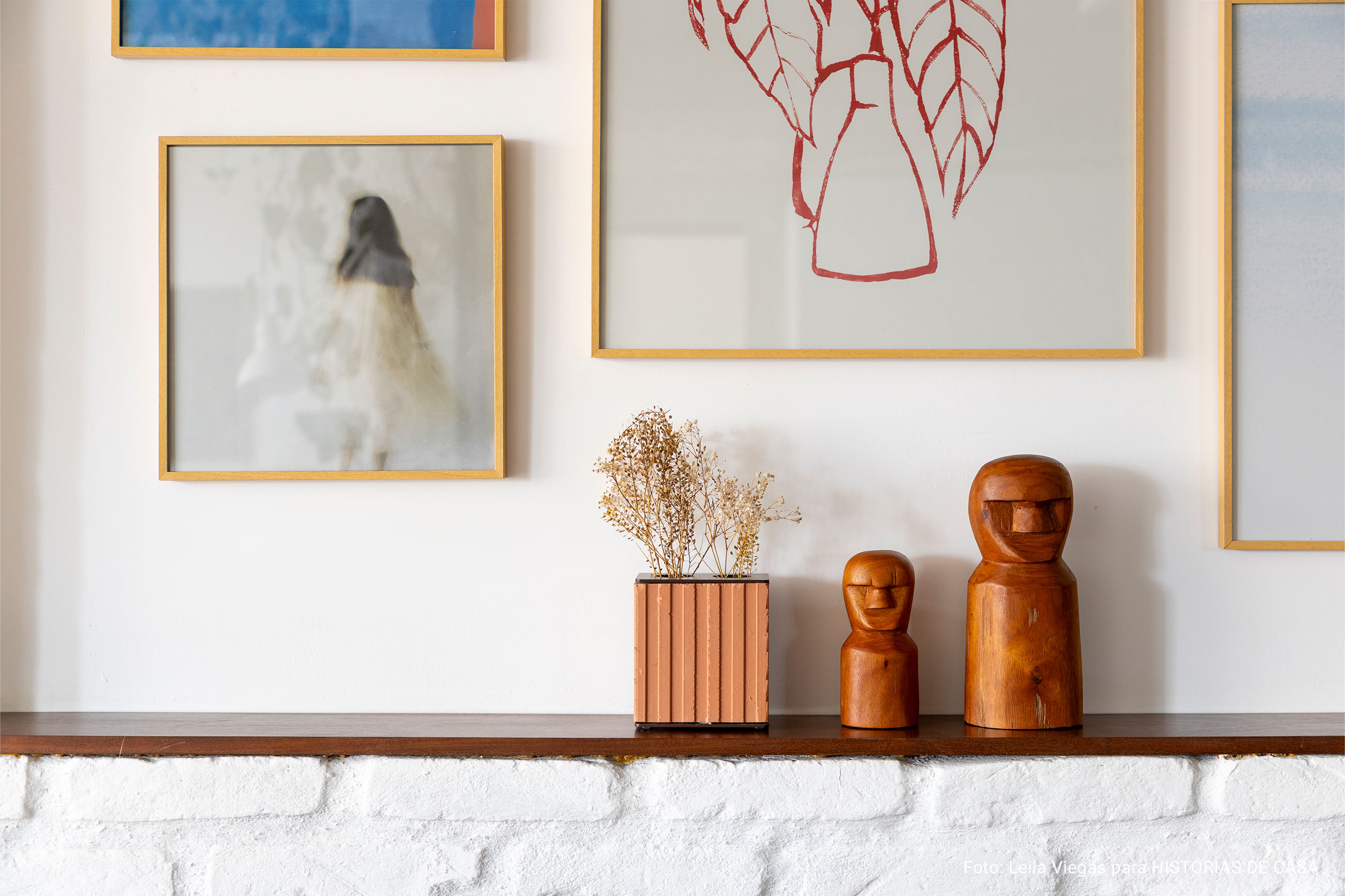 Apartamento com piso terracota, cozinha integrada e parede de quadros da Boemi.