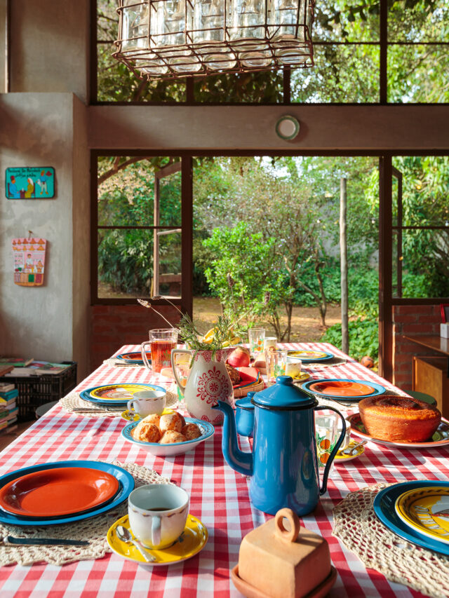 Casa de campo com cozinha aberta para a natureza e mesa posta com louças da Tok&Stok