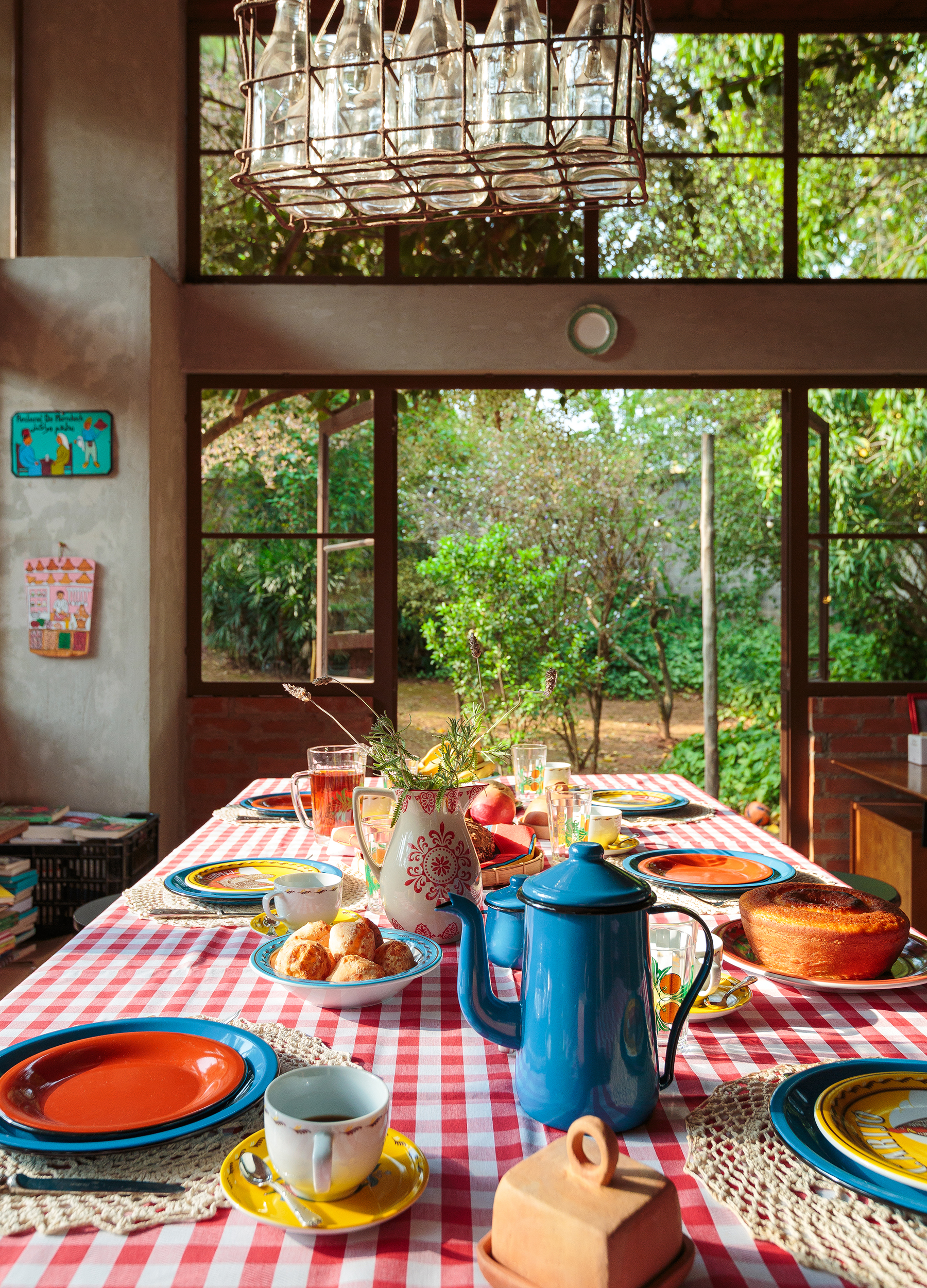 Casa de campo com cozinha aberta para a natureza e mesa posta com louças da Tok&Stok