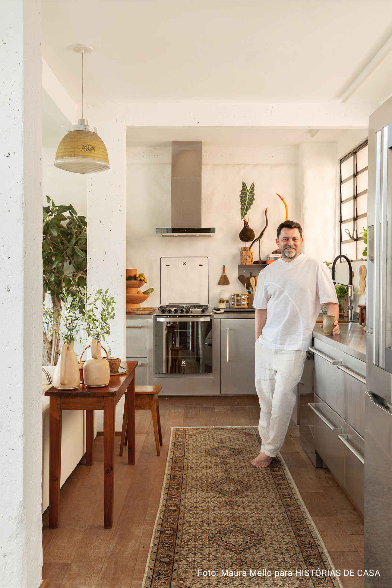 Apartamento com cozinha integrada, varanda cheia de plantas e garimpos do mundo todo