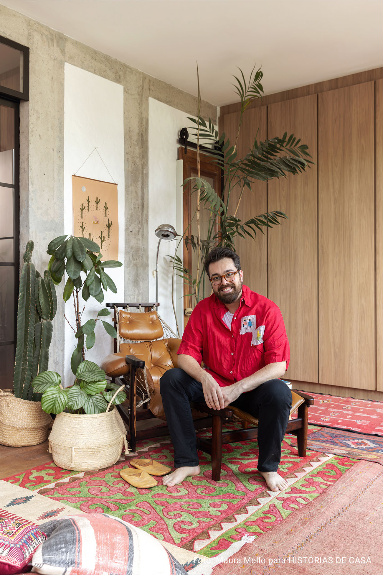 Apartamento integrado com muitos tapetes e uma varanda com plantas.