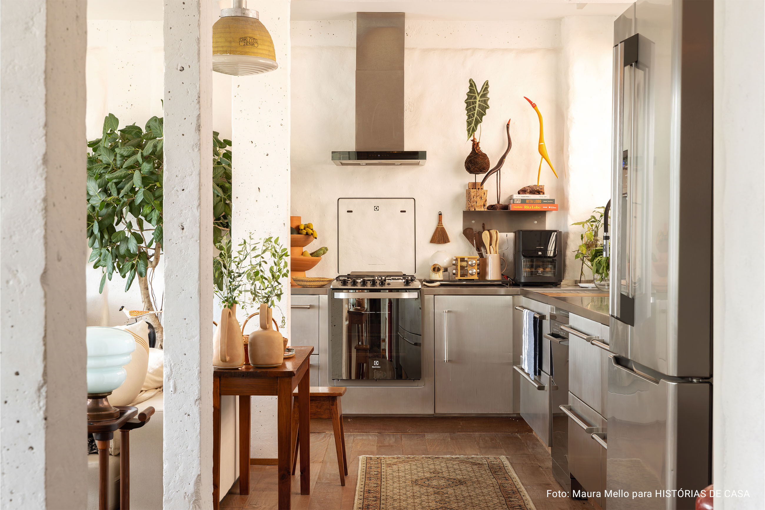 Apartamento com cozinha integrada, varanda cheia de plantas e garimpos do mundo todo