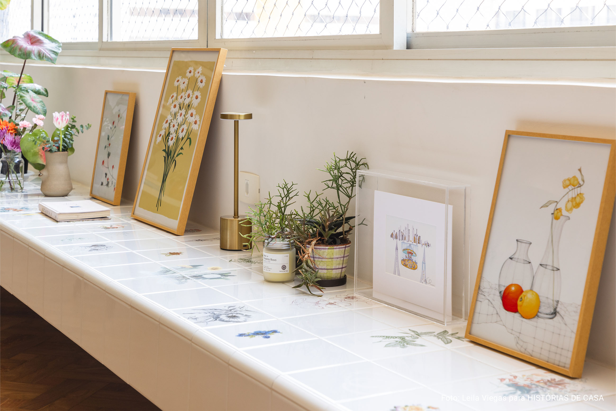 Apartamento iluminado com banco de azulejos e muitas flores