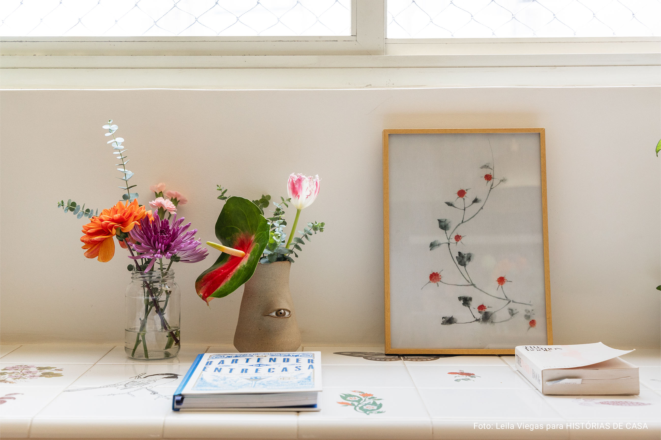 Apartamento iluminado com banco de azulejos e muitas flores